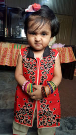 Portrait of cute girl standing at home