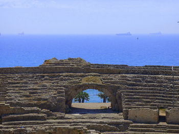 Arch bridge over sea against clear sky