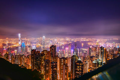 Illuminated cityscape against sky at night