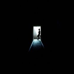 Man standing at doorway in darkroom
