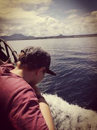 Boy in sea against sky