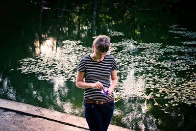 Portrait of young woman by pond