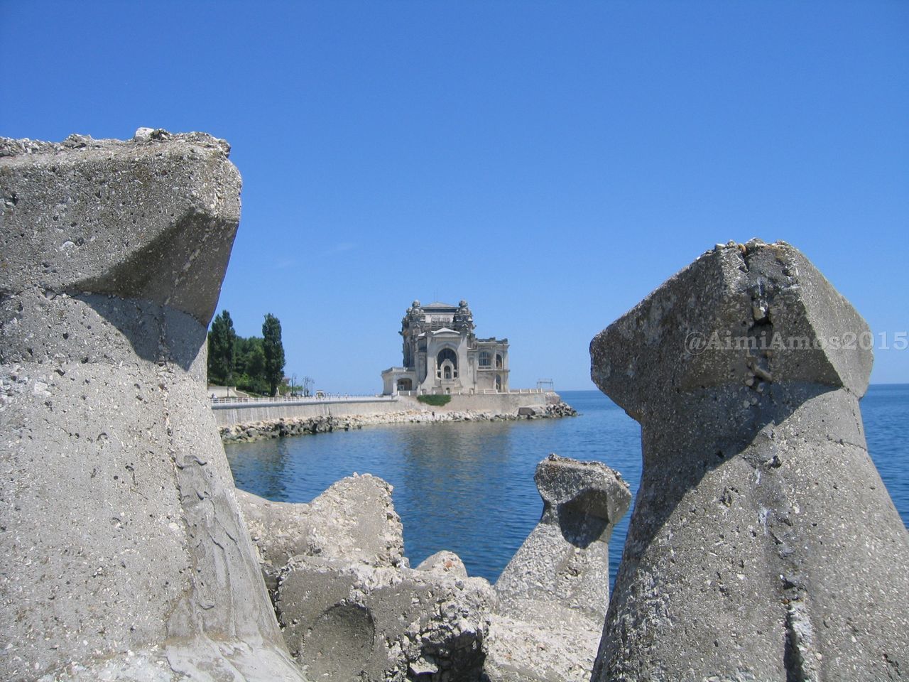 ROCKS IN SEA AGAINST CLEAR BLUE SKY