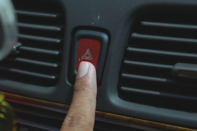 Cropped hand pressing button in car