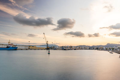 Long exposure photography  in the port at sunset, with silky water and cloudy sky.