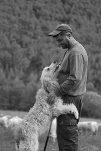 Side view of man with dog standing outdoors