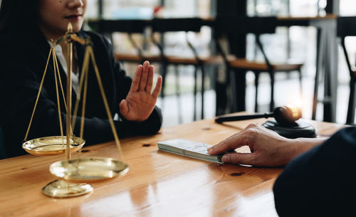 Midsection of woman using mobile phone at table