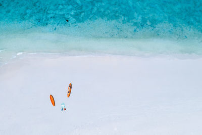 Pastel colour kayaking orange tourists on the sand beach at phuket thailand aerial top view 