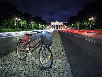 Bicycle parked on street in city at night