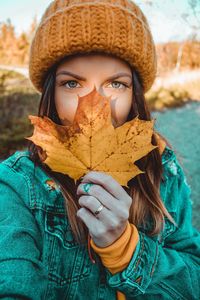 Portrait of woman holding maple leaf