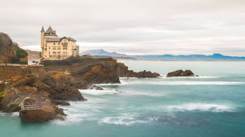 View of buildings on beach against cloudy sky