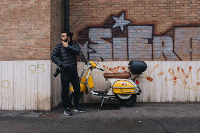 Man standing against graffiti wall