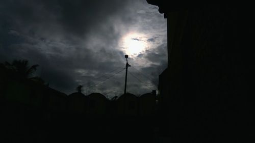 Silhouette of building against cloudy sky