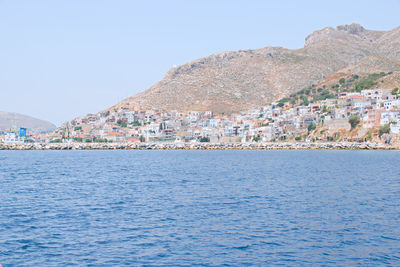 Scenic view of sea by town against sky