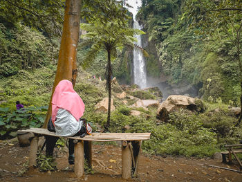 Rear view of man against waterfall