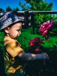 Rear view of boy on flowering plant