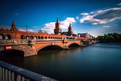 River in front of building against sky