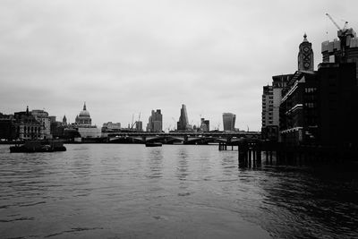 River by cityscape against sky