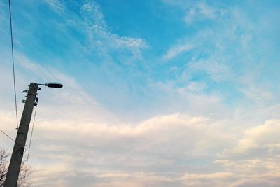 Low angle view of telephone pole against sky