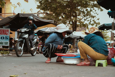 People sitting on street in city