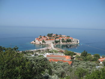 High angle view of buildings by sea against clear sky