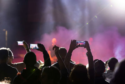 People photographing at music concert