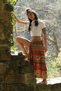 Young woman standing against brick wall