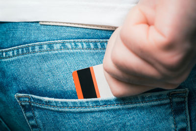 Cropped image of person pulling credit card from jeans pocket