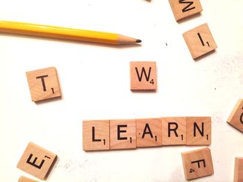 Close-up of pencil and text on blocks over table