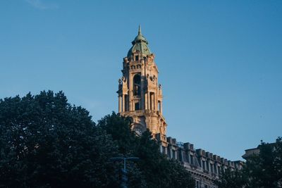 Low angle view of bell tower against blue sky