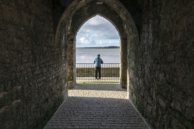 Rear view of woman walking in corridor of historic building