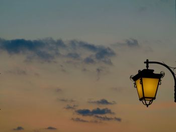 Low angle view of illuminated street light against sky