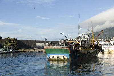 Fishing boats in sea against sky