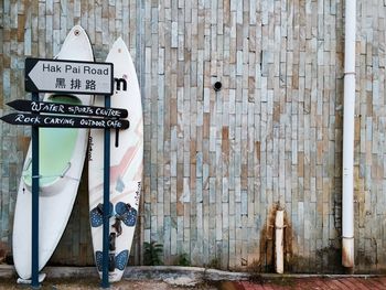 Surfboards and information sign against wall