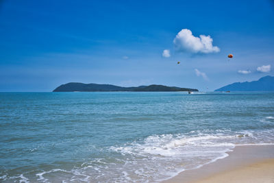 Parasailing on the waves of the azure andaman sea under the blue sky near the shores of cenang beach