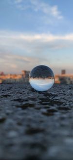 Surface level of crystal ball against sky during sunset