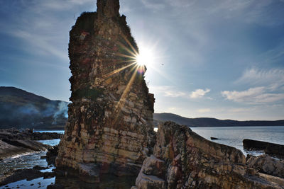 Rock formations by sea against sky