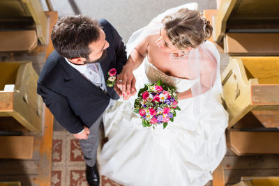 Couple holding bouquet of people