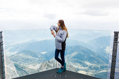 Young girl enjoys the views of the alps from the observation deck