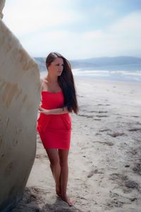 Full length of woman standing on beach against sky