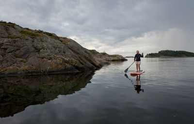 Man on rock against sky