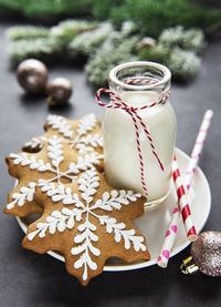 Homemade delicious christmas gingerbread cookies with bottles of milk on the black background.