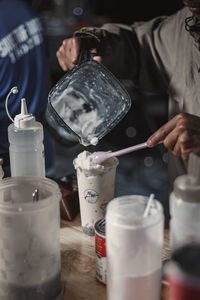 Midsection of man preparing food in glass