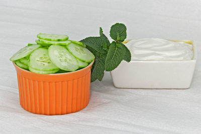 Close-up of sliced cucumber with cheese spread on table