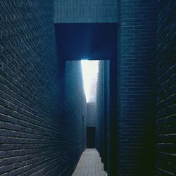 Narrow walkway along brick wall