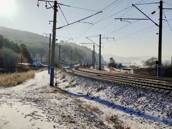 Railroad tracks against sky during winter