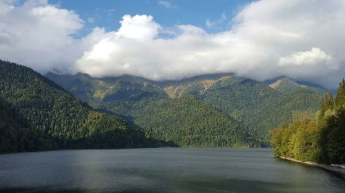 Scenic view of lake by mountains against sky