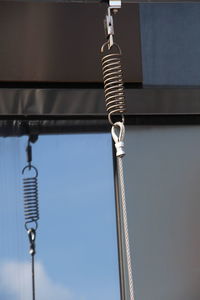 Low angle view of chain hanging on rope