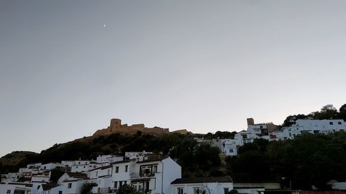 Buildings in town against clear sky