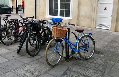 Bicycles parked on footpath by building